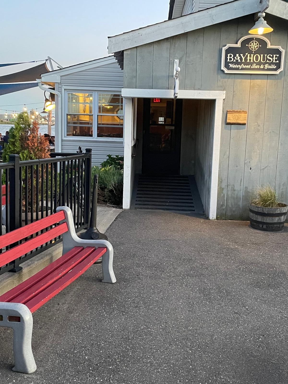 The entrance to Bayhouse, under the navy Waterfront Bar & Grille sign with its compass rose